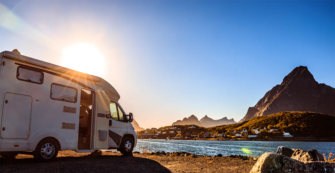 RV parked with mountains and sunset in the background, symbolizing Lemon Law rights for RVs and travel trailers in California.