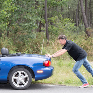 Man pushing a car, representing issues related to vehicle problems and resale value, in the context of Lemon Law violations in California